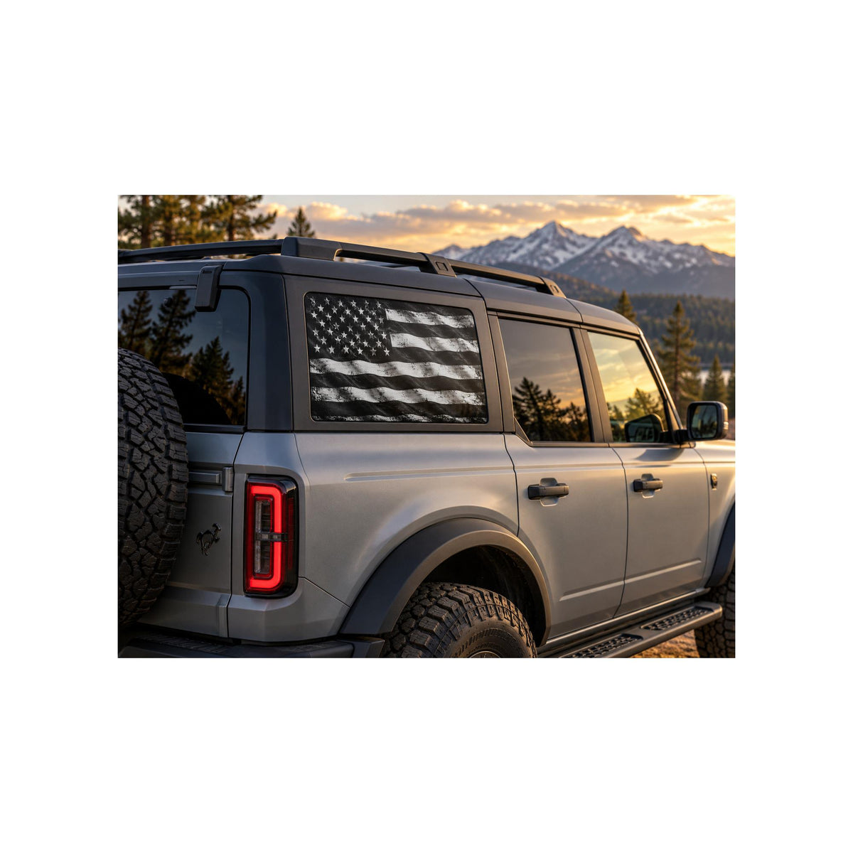 Ford Bronco rear side window with a perforated decal of a black and white distressed American flag, applied to the outside of the glass.
