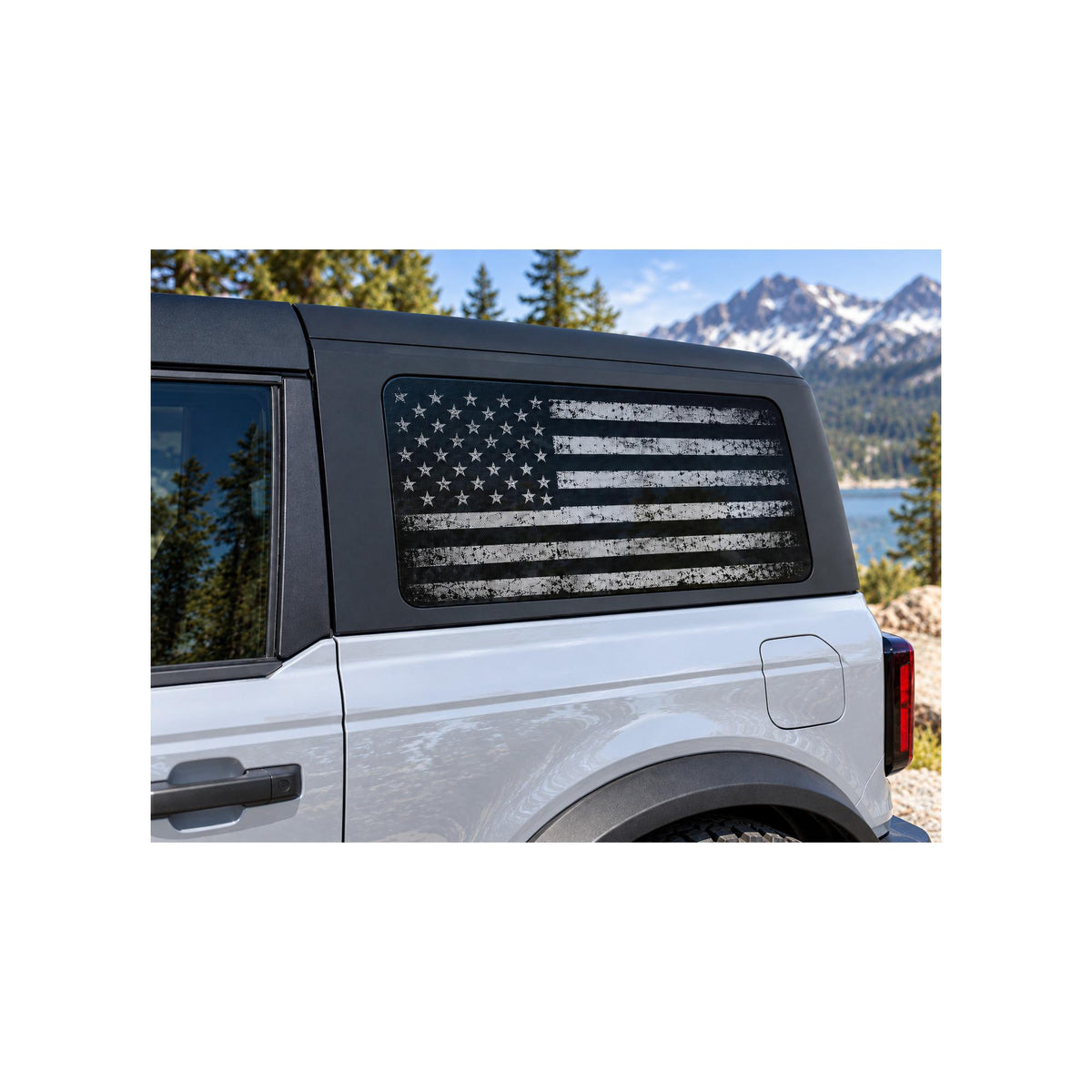 Ford Bronco rear side window with a perforated decal of a black and white distressed American flag printed edge-to-edge with no background, applied to the outside of the glass.