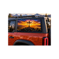 Ford Bronco rear side window with a perforated decal of a wooden cross draped with cloth on a mountaintop at sunrise, sun rays breaking through the clouds, applied to the outside of the glass.