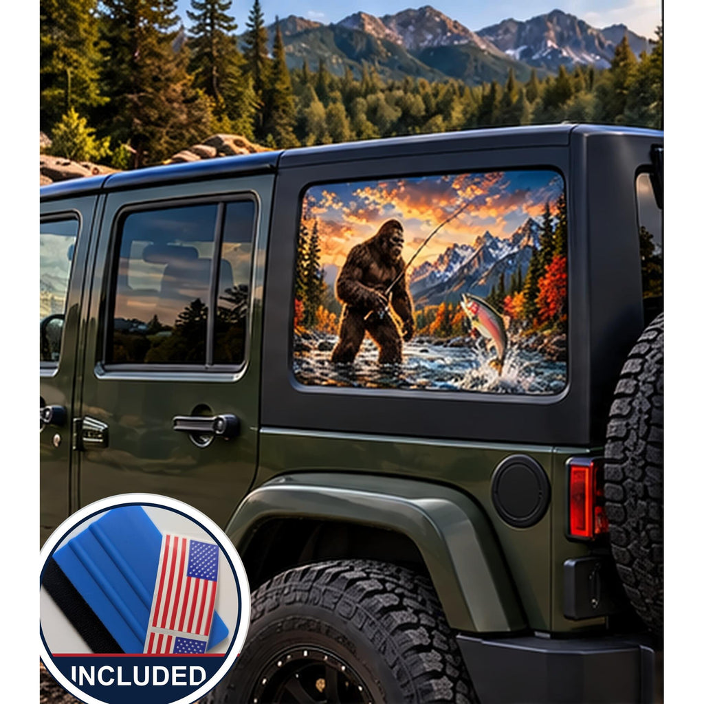 Jeep Wrangler 4-door rear quarter window with a perforated decal of Bigfoot fly-fishing in a mountain river at sunset, a trout jumping from the water, applied to the outside of the glass. An INCLUDED badge in the corner shows the felt squeegee and 2 American flag decals that come with every set.