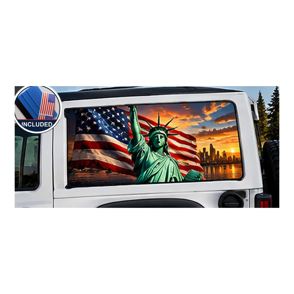 Jeep Wrangler 2-door rear side window with a perforated decal of the Statue of Liberty holding her torch in front of a waving American flag and the New York City skyline at sunset, applied to the outside of the glass. An INCLUDED badge in the corner shows the felt squeegee and 2 American flag decals that come with every set.